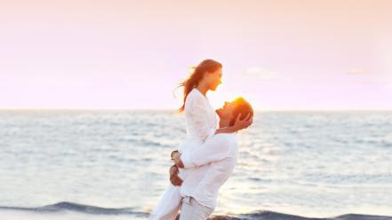 Brunettes sunset ocean couple embrace bracelets white clothes wallpaper
