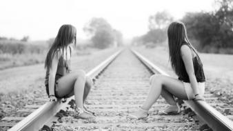 Grayscale railroad tracks girls in nature